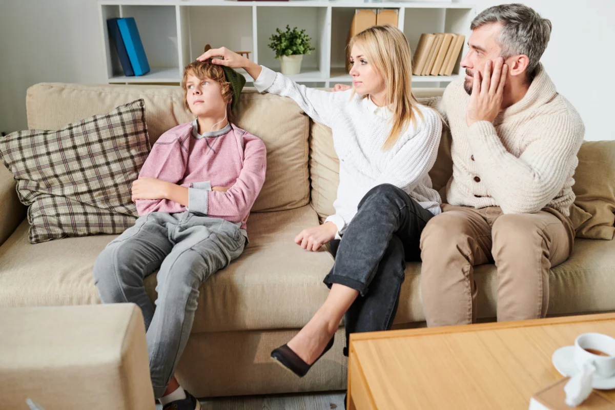Padres hablando con su hijo en casa durante un momento delicado sobre cómo decirle a mis hijos que nos separamos de forma sincera y adaptada a su edad.